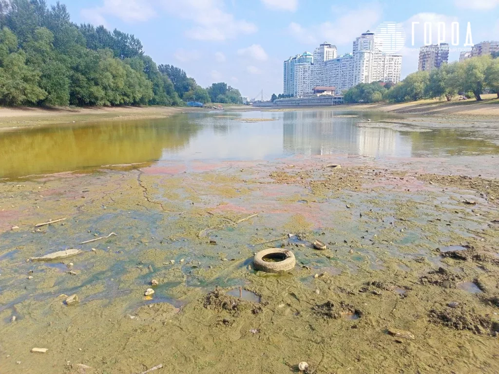 Красные пятна и покрышки в обмелевшей Кубани на Затоне Краснодара. 