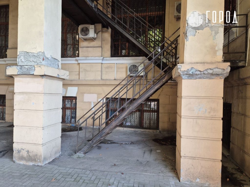 С левого торца здания, если смотреть с улицы Красной