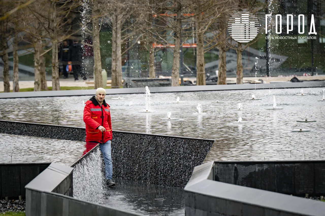 Рабочий идёт через новый водоём в парке Галицкого