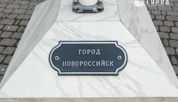 Табличка под флагом города-героя Новороссийск у здания Заксобрания Краснодарского края